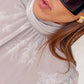 Blusa jacquard con collo alto e maniche a sbuffo