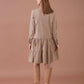 Abito a quadri beige con balze