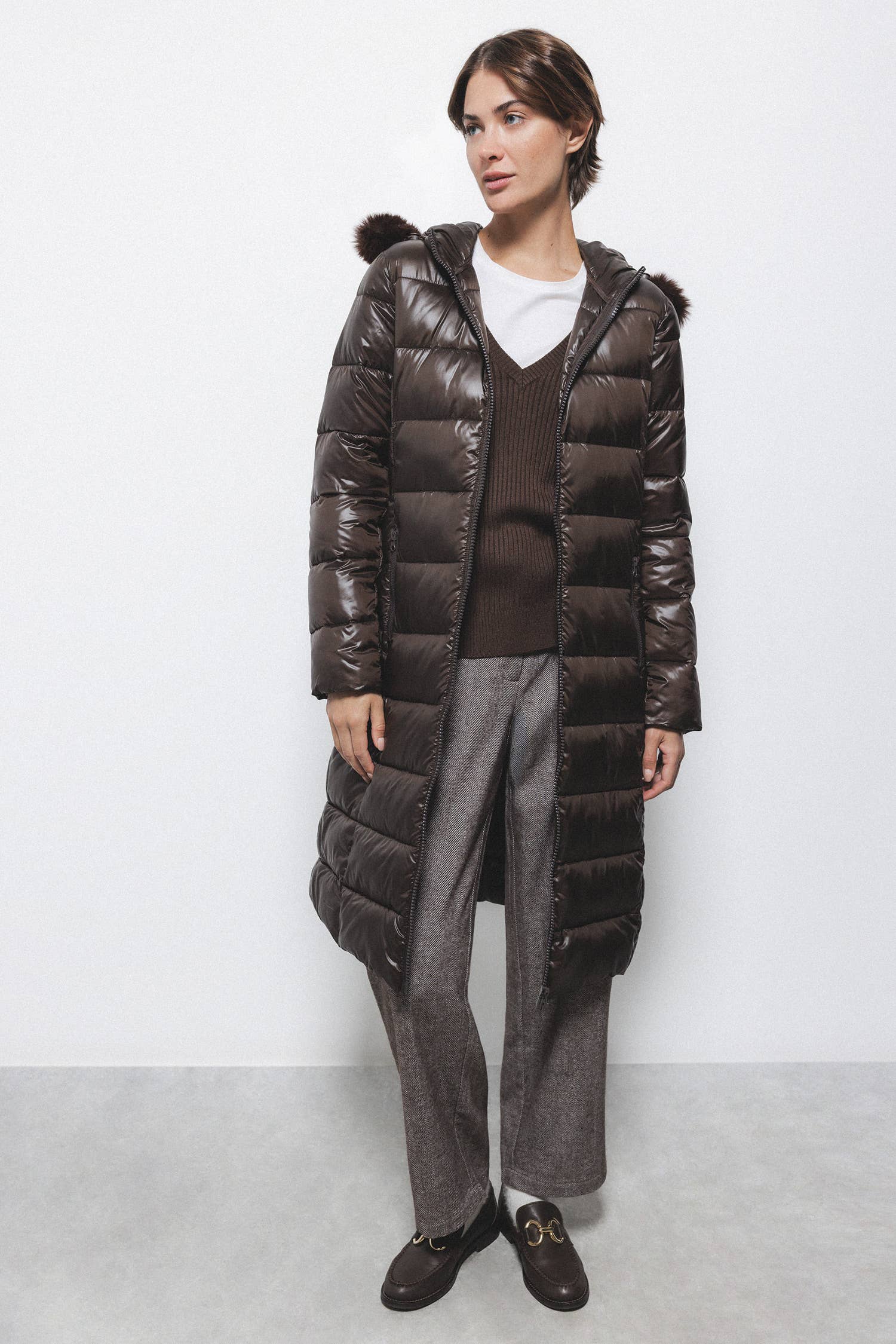Cappotto lungo imbottito con cappuccio e bordatura in eco-pelliccia