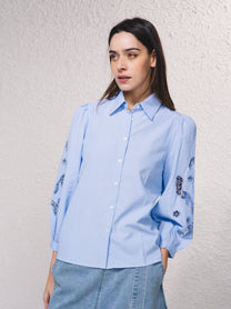 Blusa azzurra con maniche ricamate