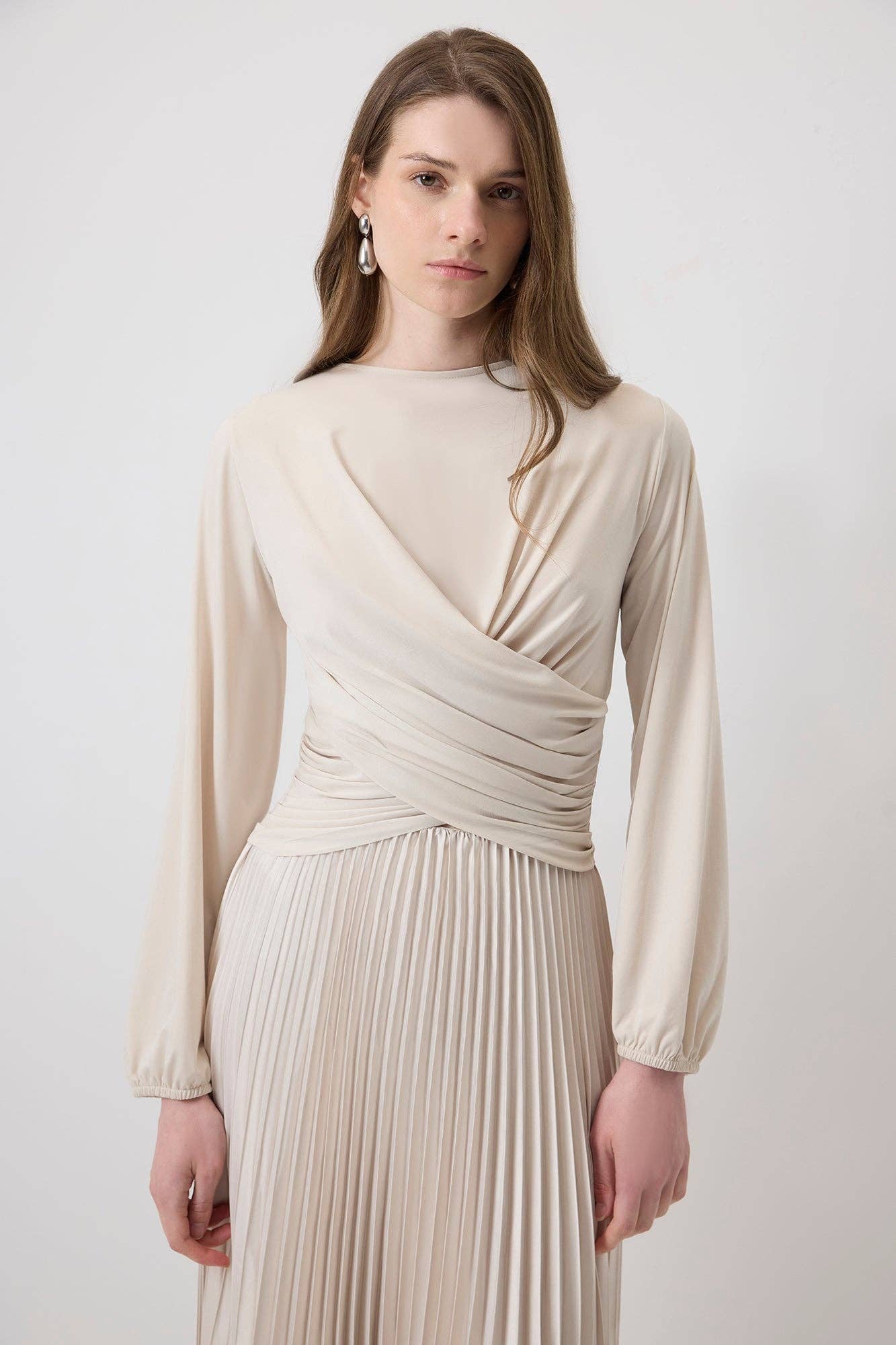 Blusa crema drappeggiata con orlo plissé e maniche a palloncino