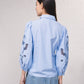Blusa azzurra con maniche ricamate