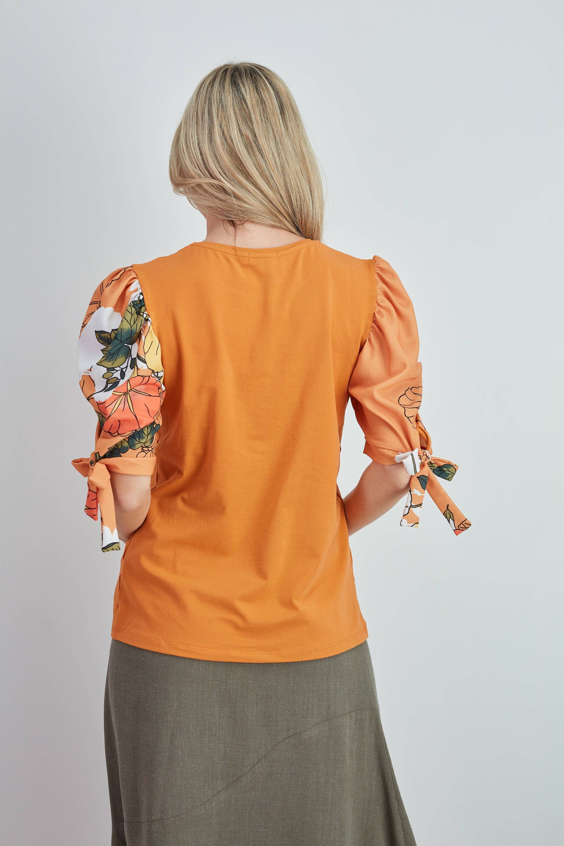 Top in cotone arancione con maniche a sbuffo floreali