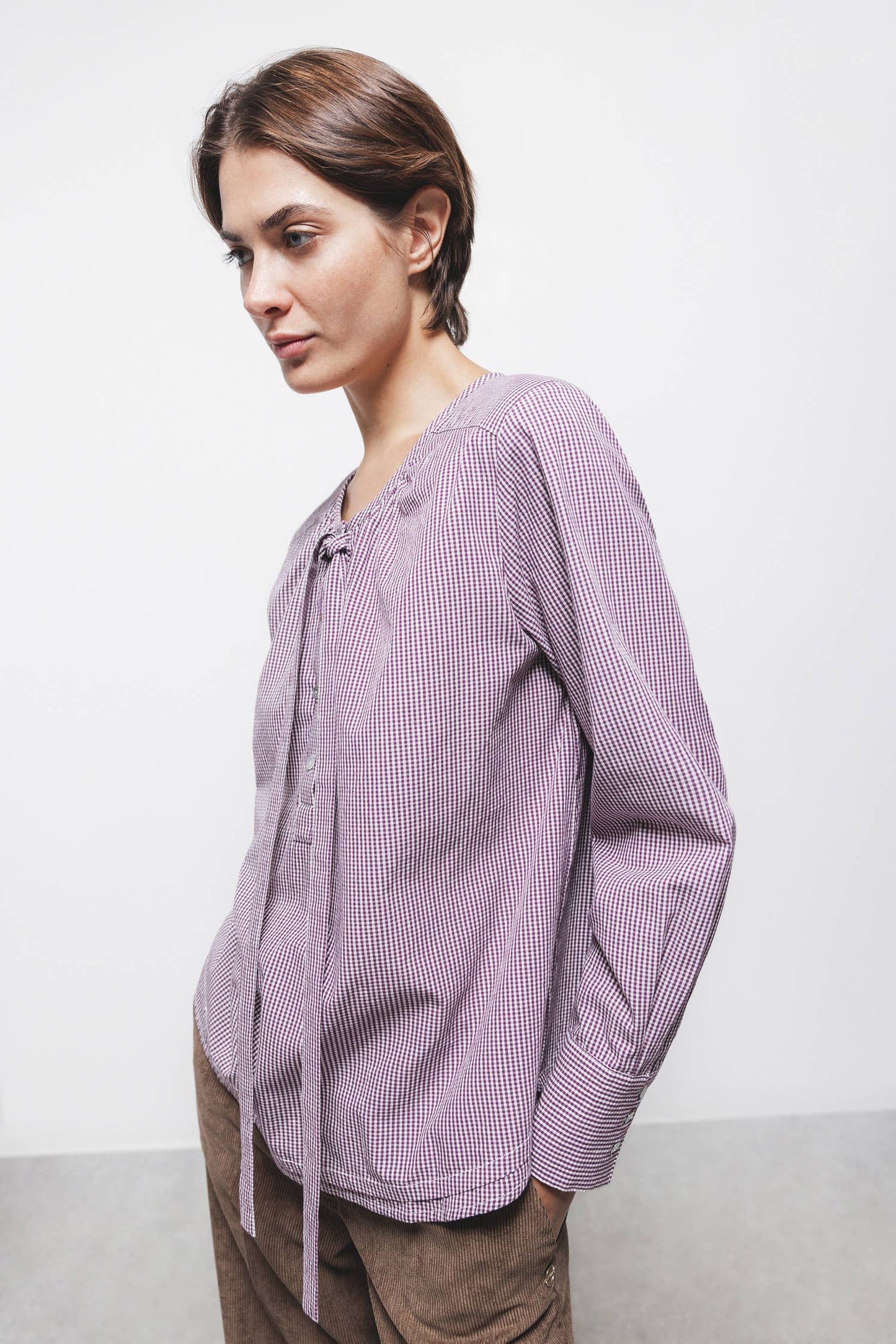 Blusa a quadretti con fiocco e bottoni a contrasto
