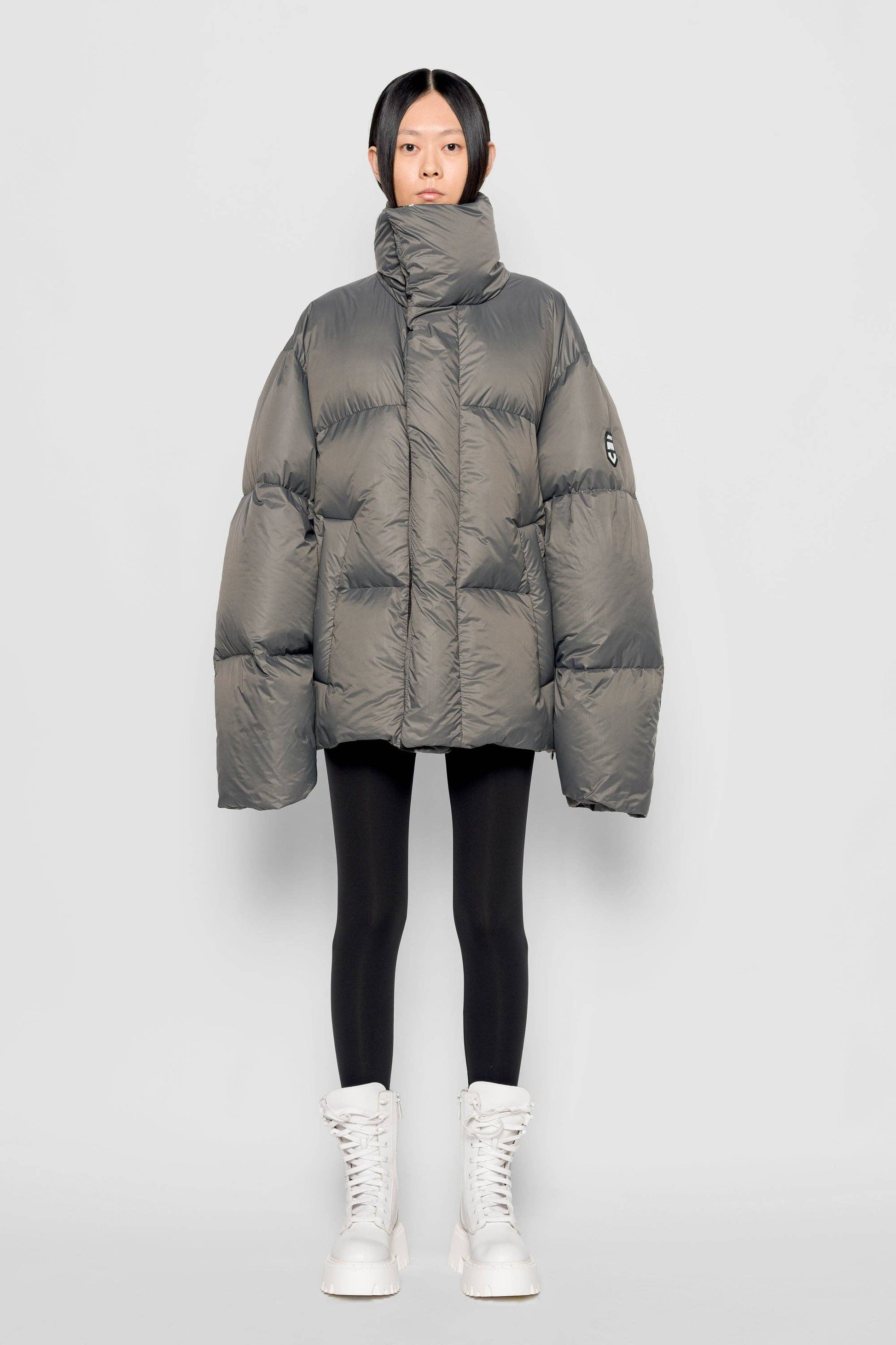 Piumino oversize con collo alto color pietra