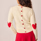 Maglione bianco in maglia con toppe a cuore e bottoni sul retro
