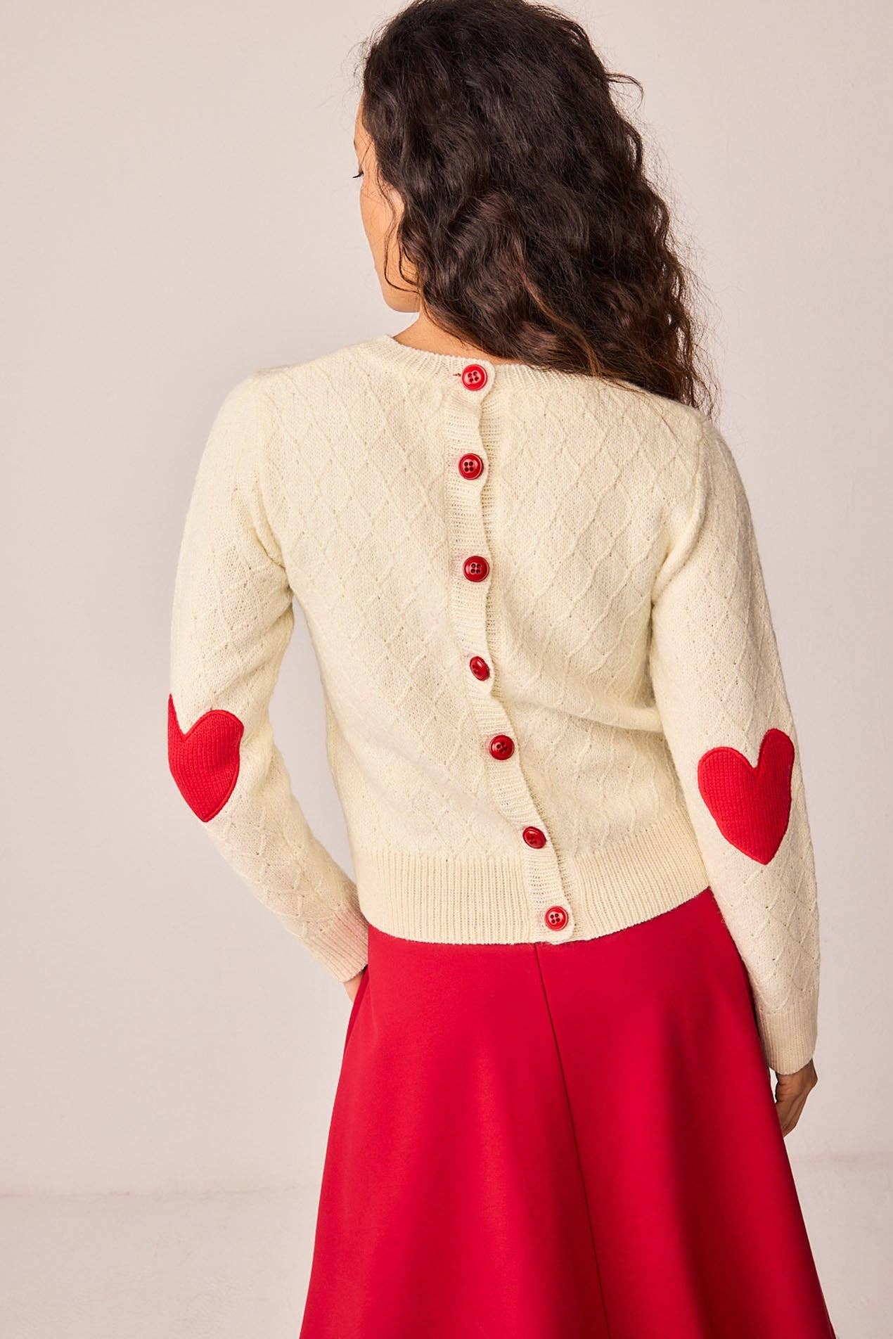 Maglione bianco in maglia con toppe a cuore e bottoni sul retro