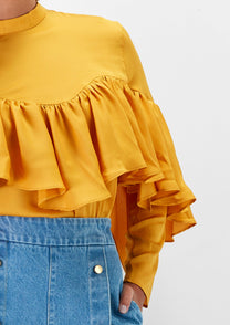 Blusa gialla con balze e pieghe sul petto