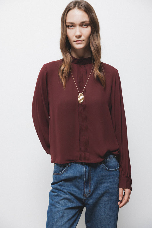 Blusa tinta unita con collo alto