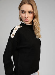 Maglione nero con collo alto e bottoni gioiello sulle spalle
