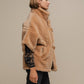 Cappotto teddy corto con collo alto e fibbie