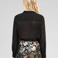 Blusa nera trasparente con volant
