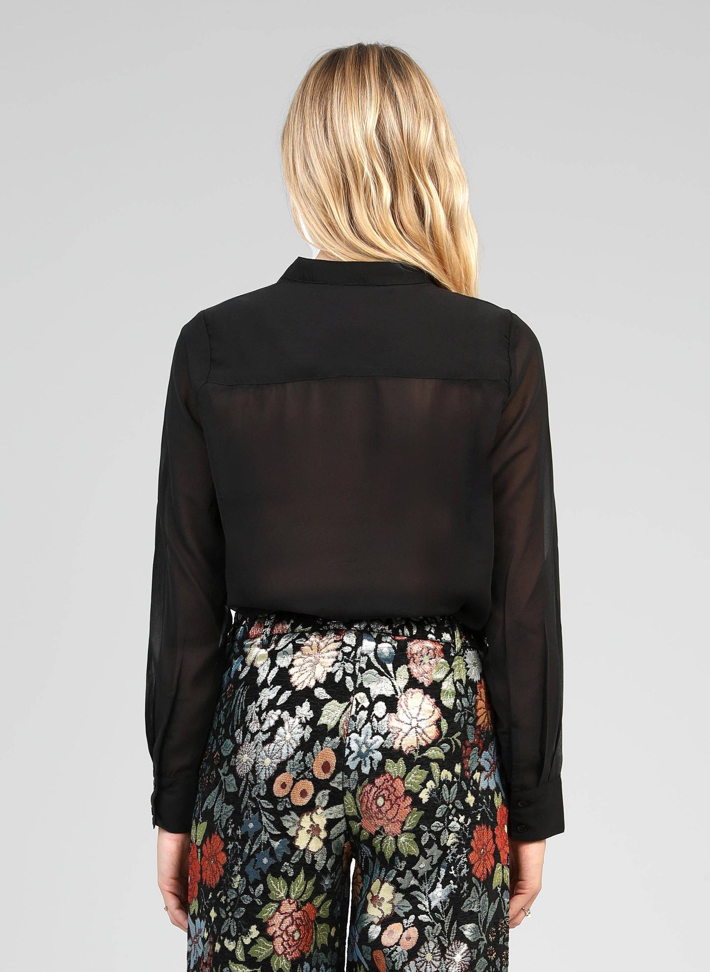 Blusa nera trasparente con volant