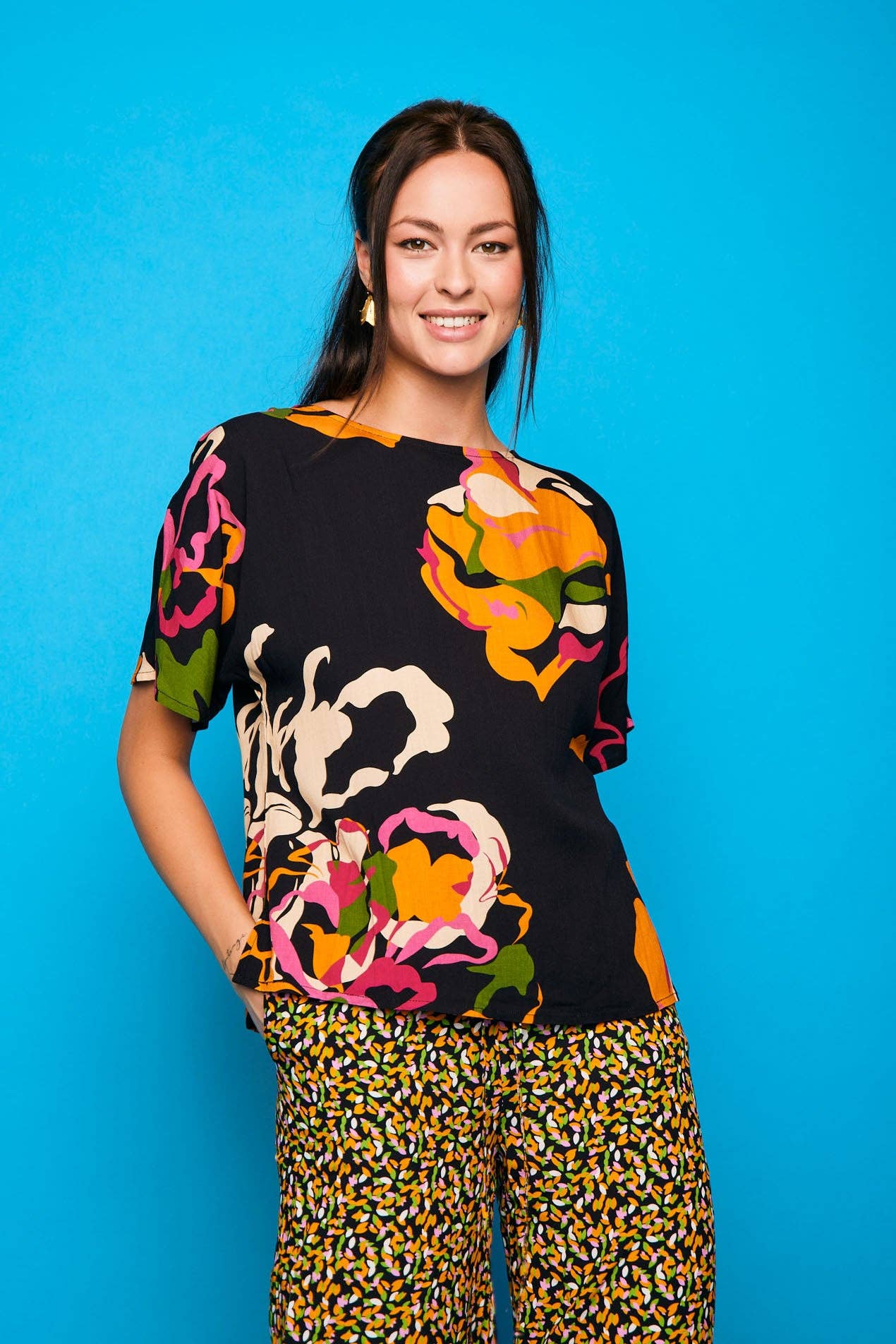 Camicia nera a maniche corte con stampa floreale e bottoni sul retro
