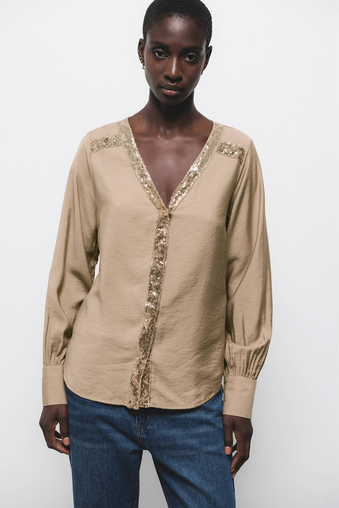 Blusa beige con scollo a V e dettagli di paillettes