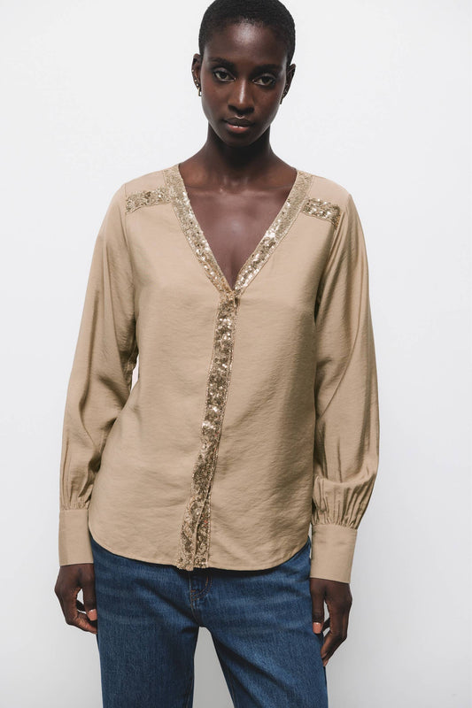 Blusa beige con scollo a V e dettagli di paillettes